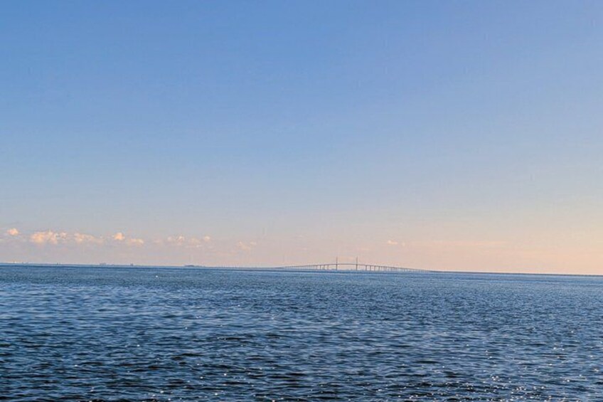 A calm sea with a distant bridge. 4