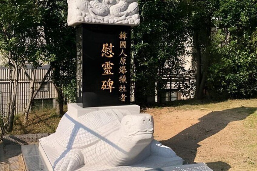 A stone monument with a lion statue and Chinese inscriptions. 3