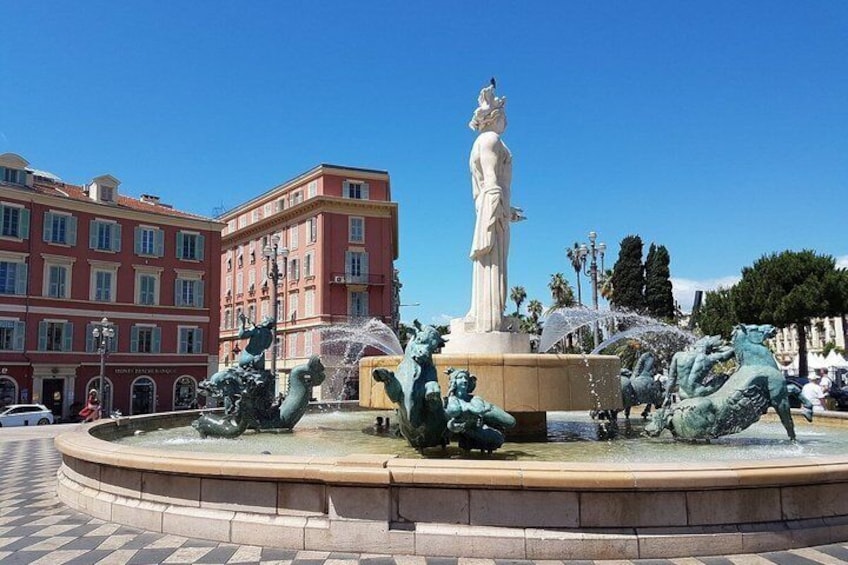 A fountain with statues and a building in the background. 3