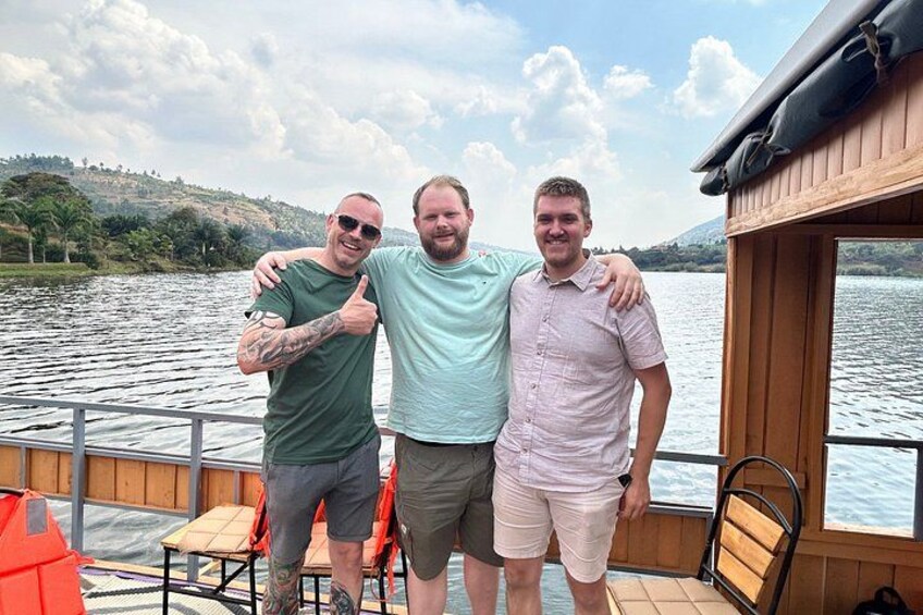 Three people on a boat with a lake and hills in the background. 5