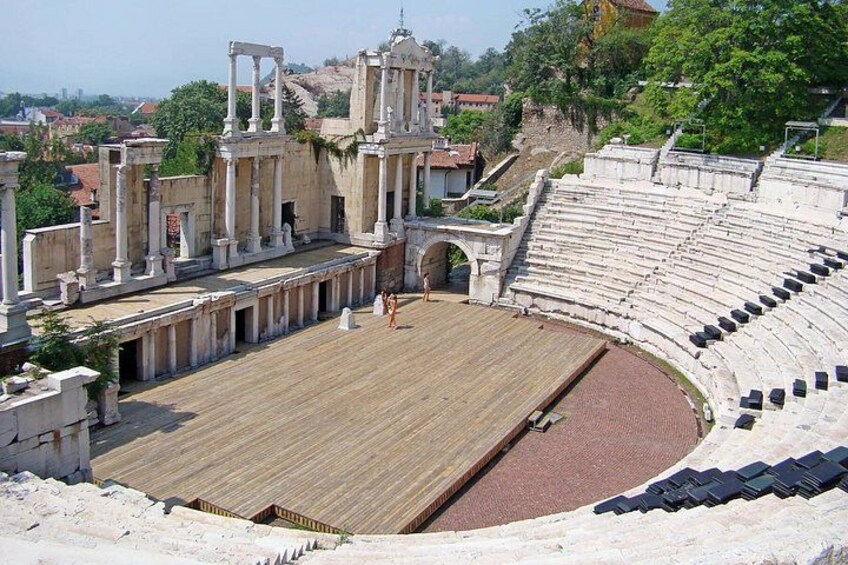 An ancient amphitheater with stone seating and columns. 4