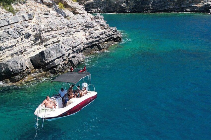 A boat with people on a rocky coastline. 2