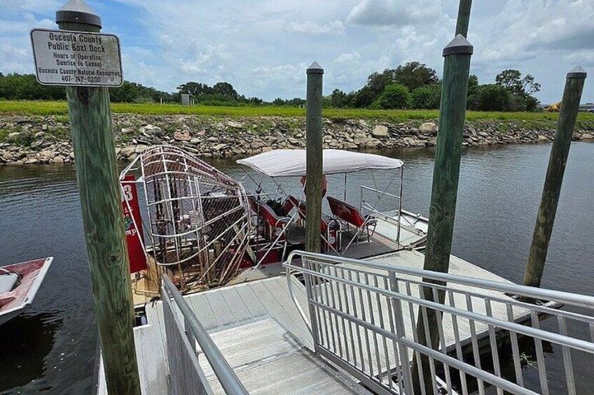 A dock with a boat, a covered area, and a sign indicating it's a public boat dock. 3