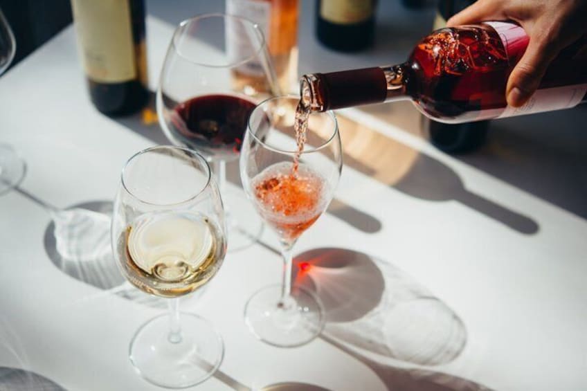 A person pouring wine into a glass. 5