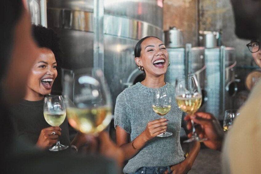 A group of people holding wine glasses in a bar setting. 3