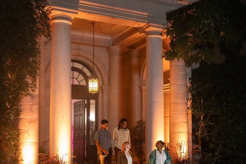 A building with large columns and a doorway, surrounded by greenery. 5