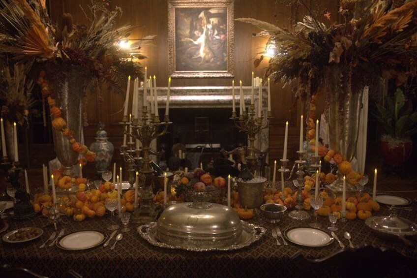 A formal dining table set with candles, fruits, and a central decorative piece. 2