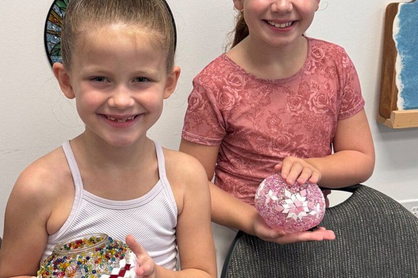 Two children holding decorated objects. 4