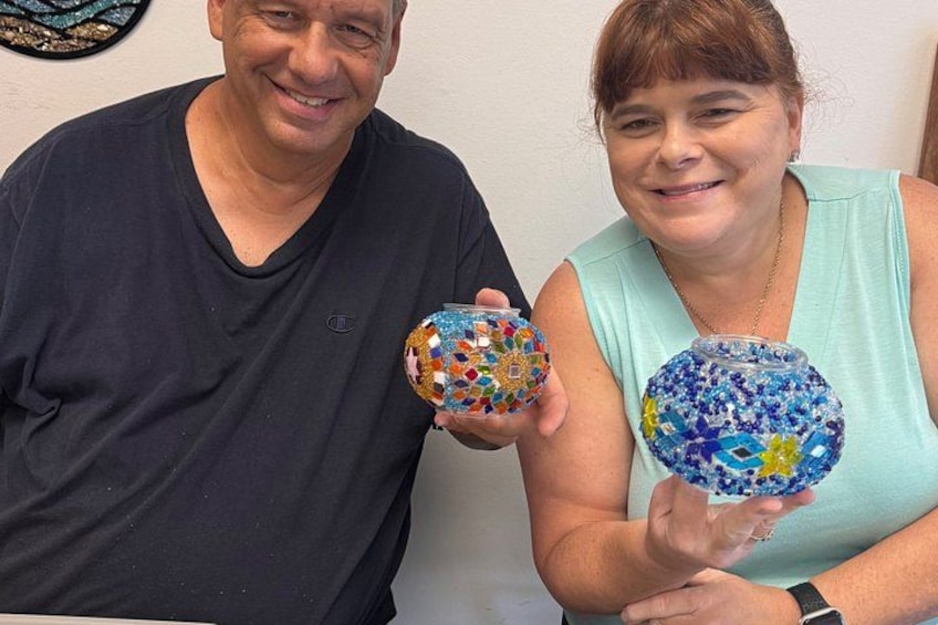 Two people holding decorative glass bowls. 3