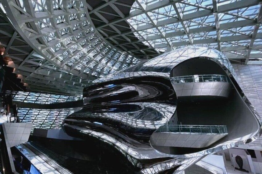 A modern architectural structure with a reflective surface and a glass ceiling. 5
