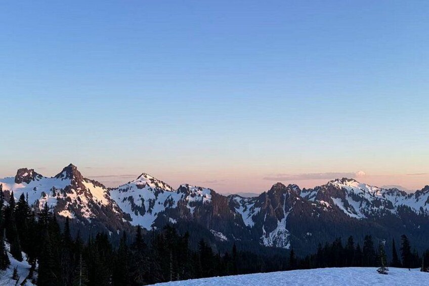 Snow-covered mountains, a clear sky, and a forested valley. 3