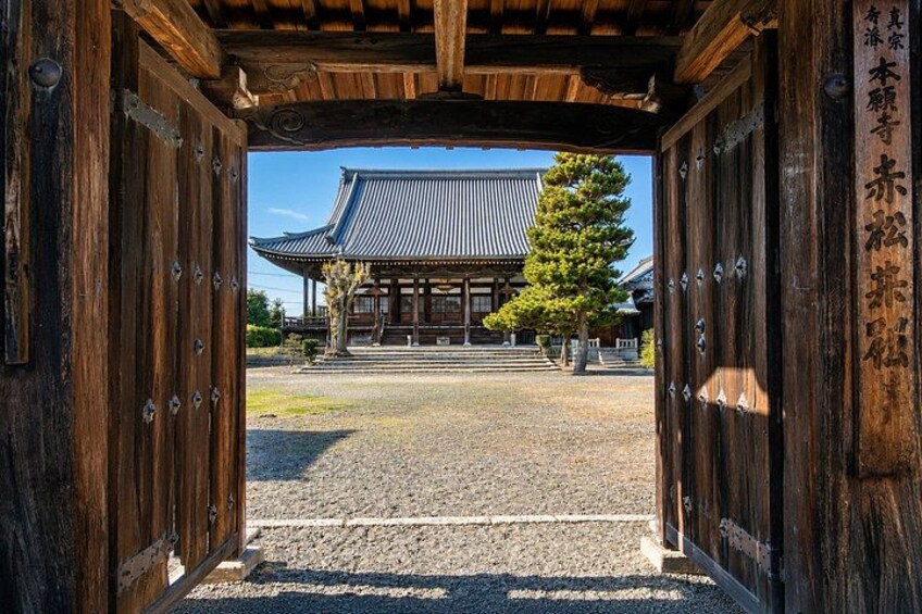 A traditional wooden gate leading to a building with a tiled roof. 5