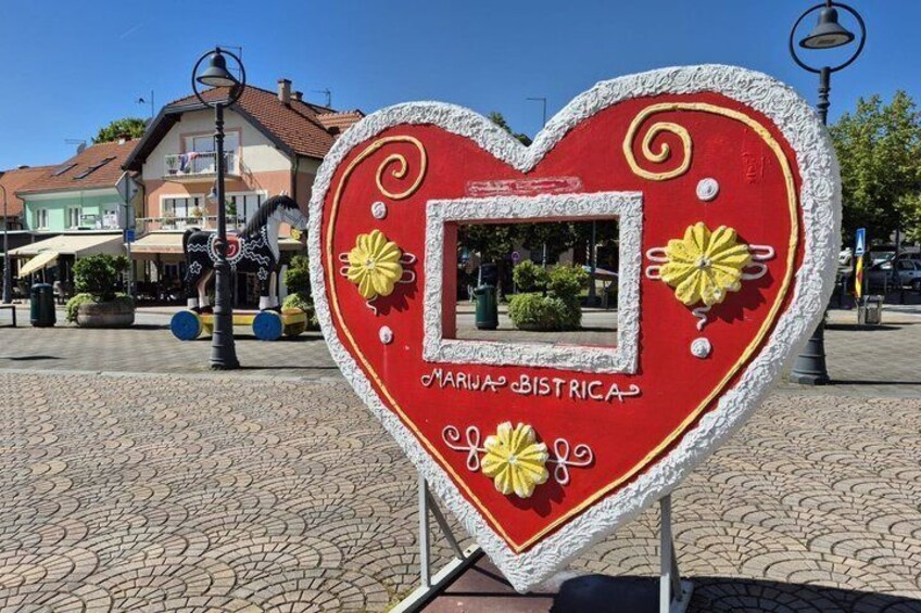 A heart-shaped sign with decorative elements and text. 3
