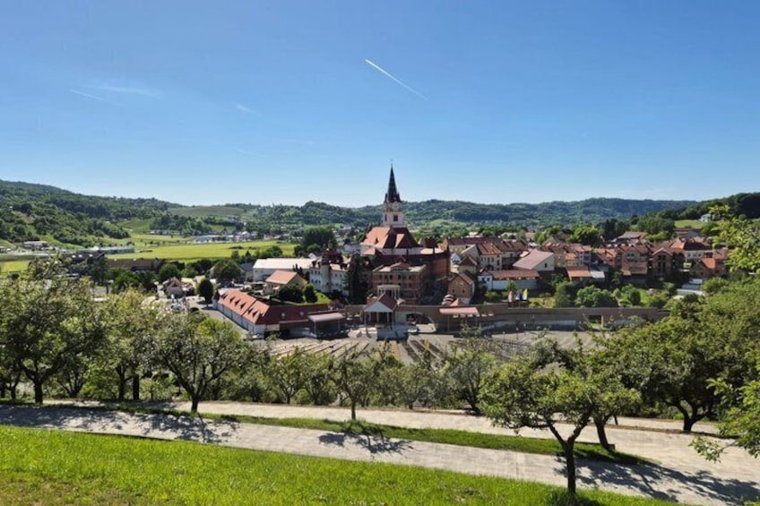 A town with a prominent church, surrounded by greenery and hills. 1