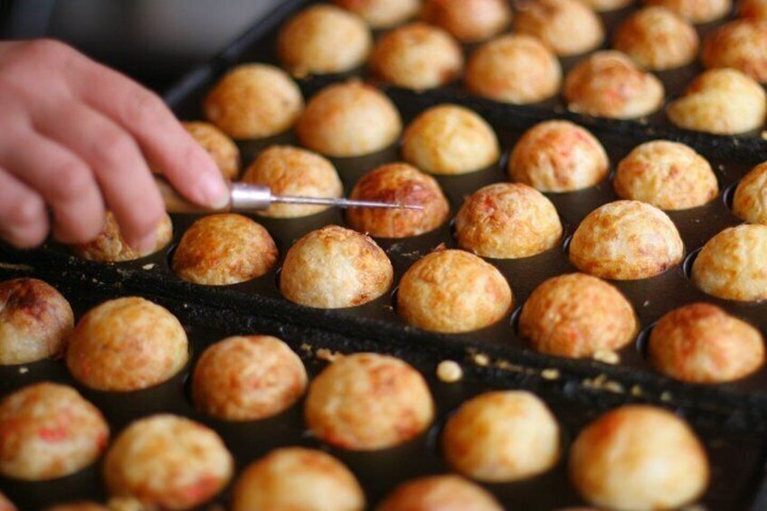 A tray of golden-brown pastries being cooked on a grill. 2