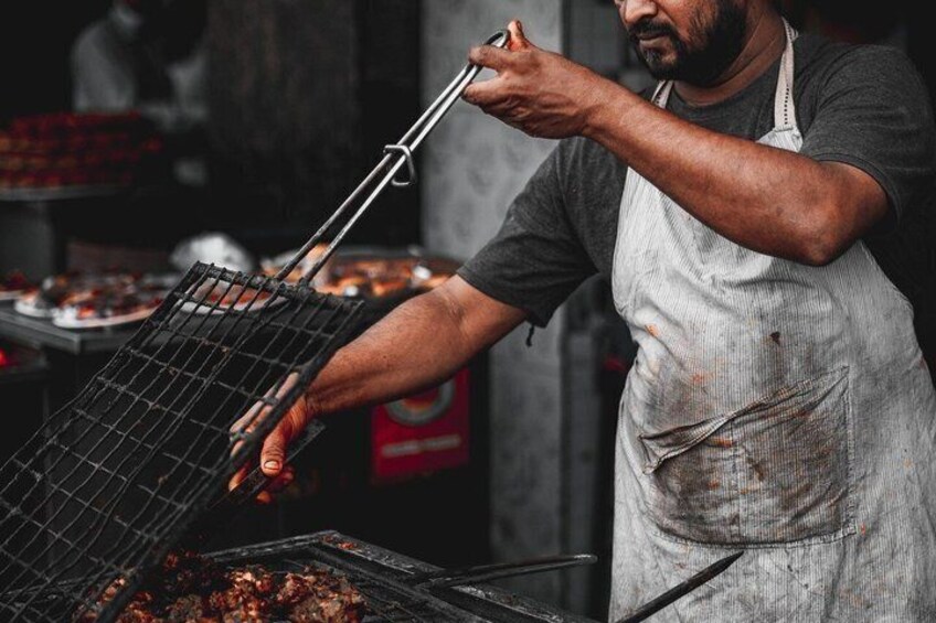 A person grilling food outdoors. 3