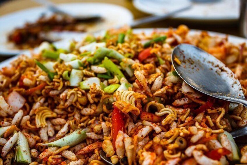 A close-up of a stir-fried noodle dish with vegetables and possibly seafood. 5