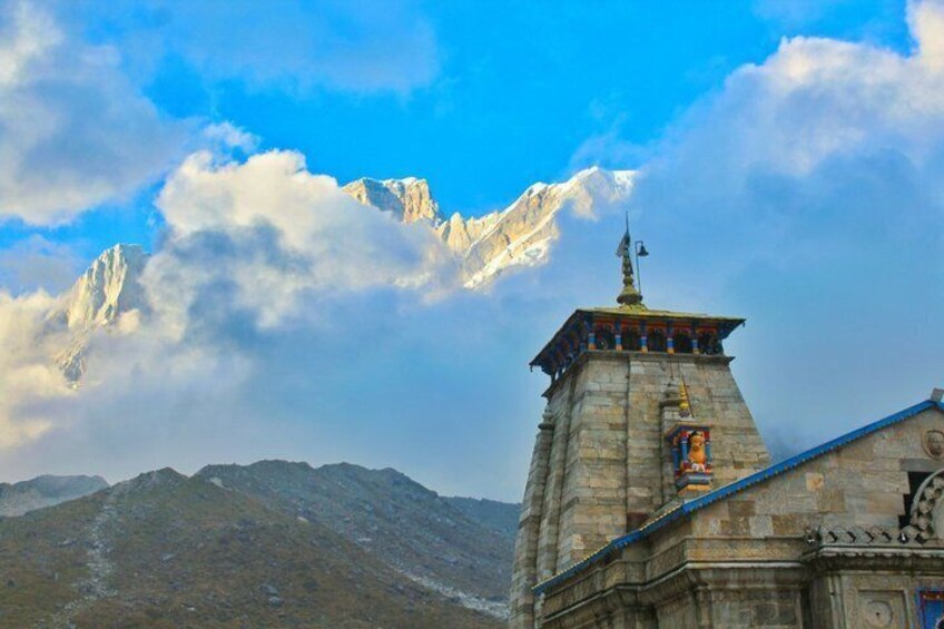 A mountain with a stone tower and a building with a blue roof. 4