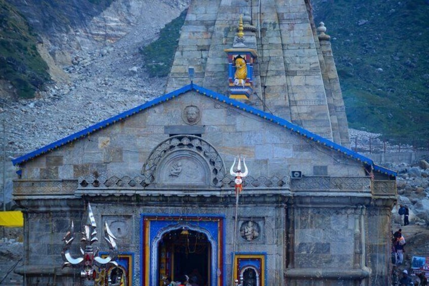 A temple with a blue roof, a central deity statue, and a trident symbol. 2