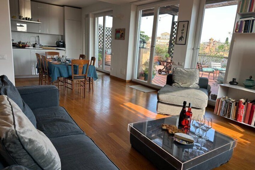 A modern living room with a sofa, coffee table, and dining area. 1