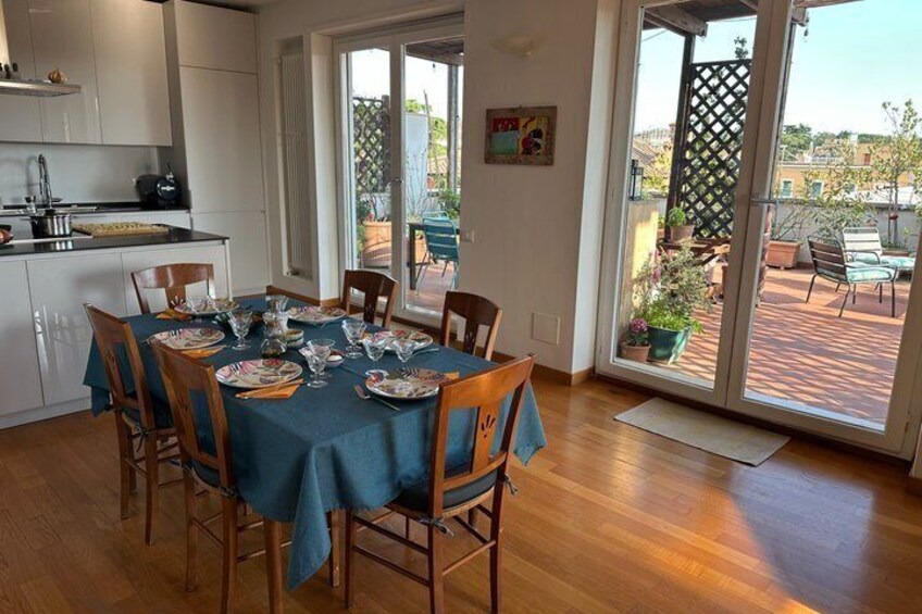 A dining area with a table set for six, wooden chairs, and a view of the outdoor patio through glass doors. 5