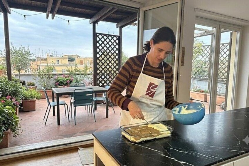 A person in an apron preparing food on a kitchen counter. 3