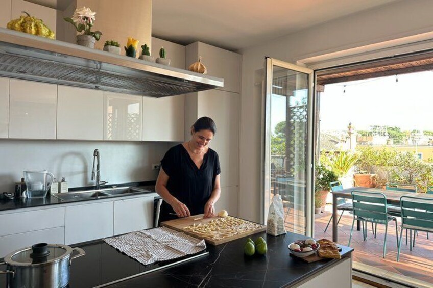 A modern kitchen with a person preparing food, a large window, and a view of the outdoors. 2