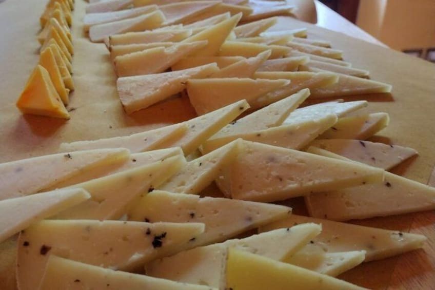 A wooden cutting board with cheese slices arranged in a pattern. 2