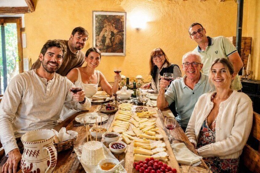 A group of people seated around a long table with various food items and drinks. 5