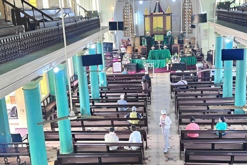 A church interior with pews, a pulpit, and a choir stand. 2
