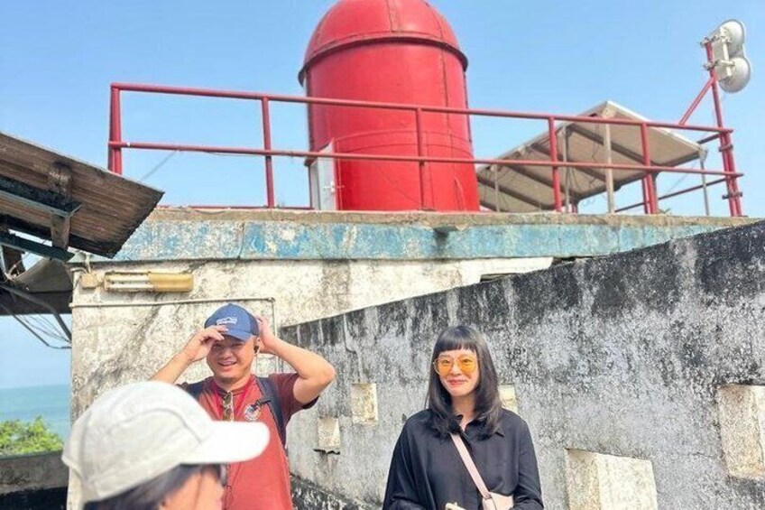 A red cylindrical structure, possibly a water tower, with a metal railing and a concrete wall. 4