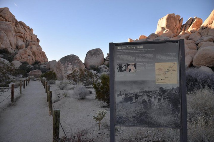 A desert landscape with a signboard titled 'Hidden Valley Trail.' 2
