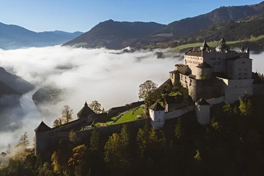 A castle on a hill overlooking a valley shrouded in mist. 5