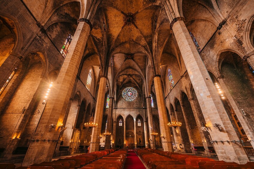 A cathedral interior with high vaulted ceilings, stained glass windows, and rows of pews. 3