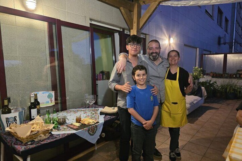 A group of people standing in an outdoor setting with a table of food and drinks. 4