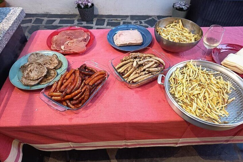 A table with various food items including sausages, bread, and French fries. 2
