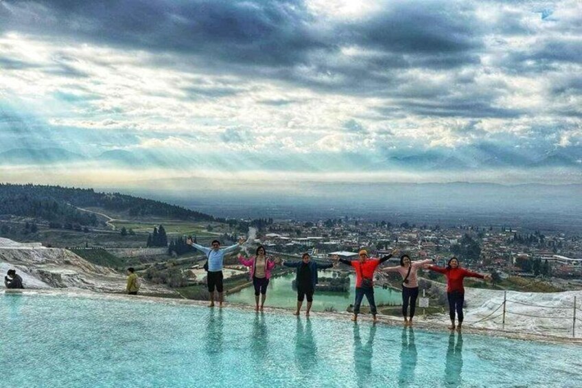 A group of people standing on a pool edge with a cityscape in the background. 3