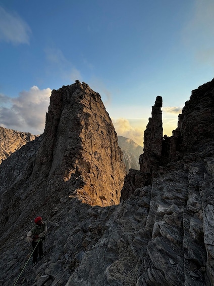 A rocky mountain landscape with a climber in red gear. 3