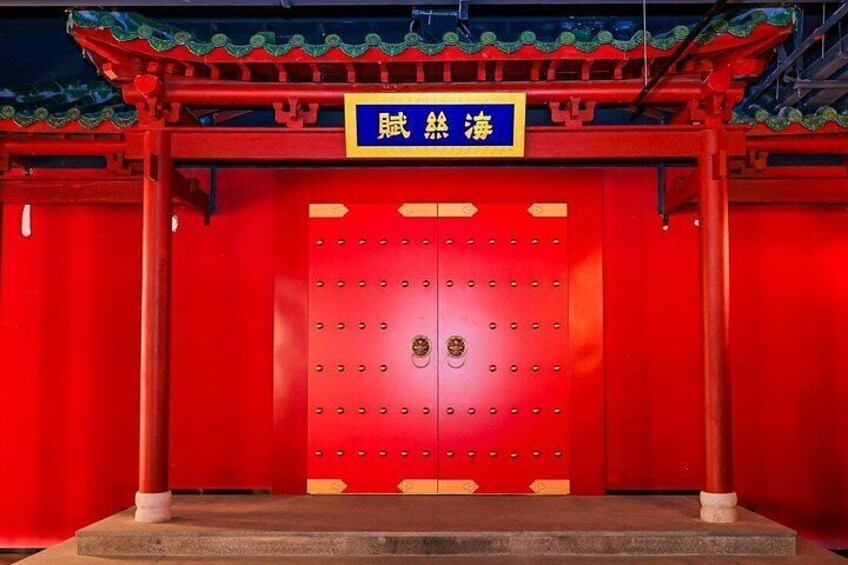 A red traditional Chinese gate with a blue sign above it. 3