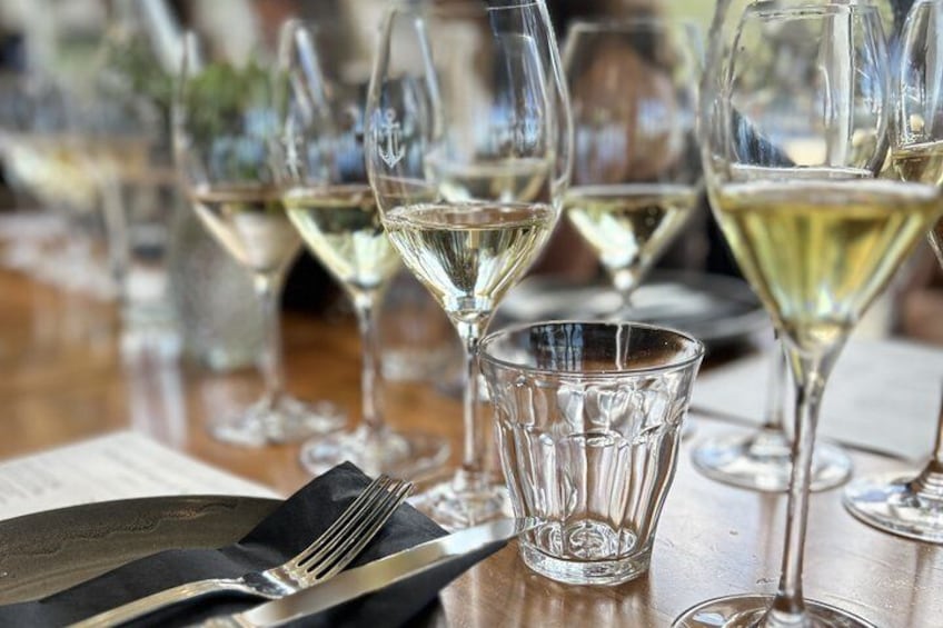 A table with wine glasses and cutlery. 2