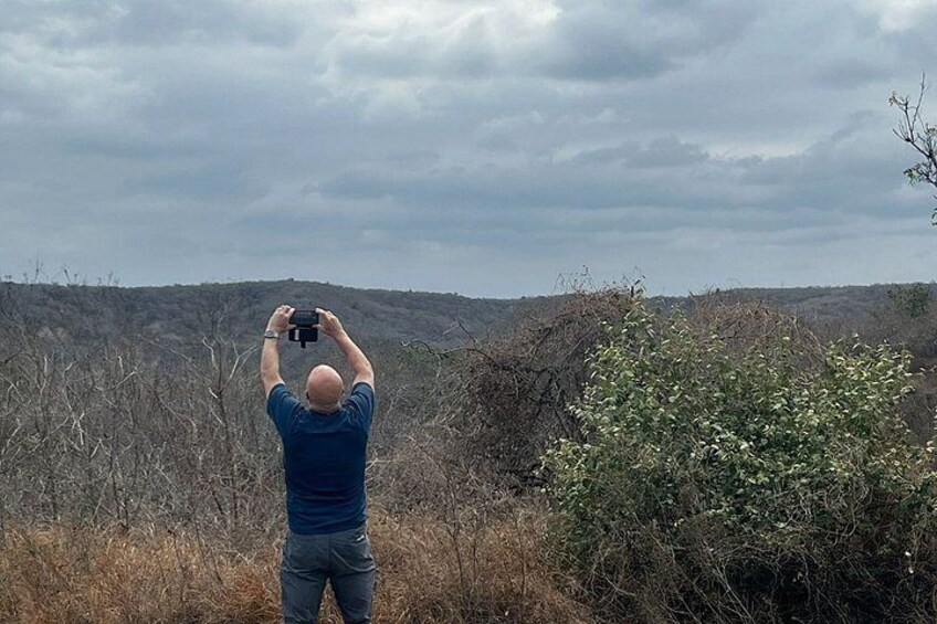 A person taking a photo with a camera in a natural landscape. 3