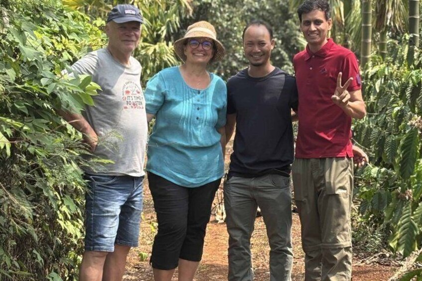 Four people standing in a garden with dense foliage. 3