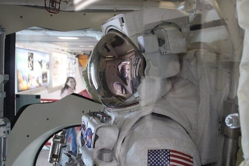 A space suit with an American flag patch, a helmet, and a space station interior. 4