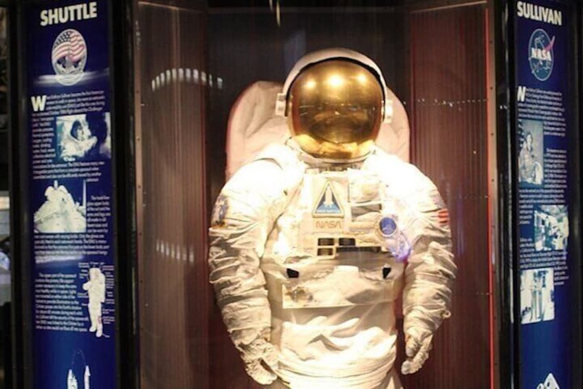 A space shuttle mannequin inside a display case with informational panels on either side. 2