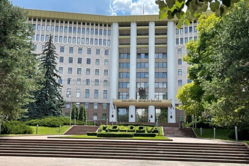 A large government building with a central entrance, surrounded by trees and a well-maintained lawn. 2
