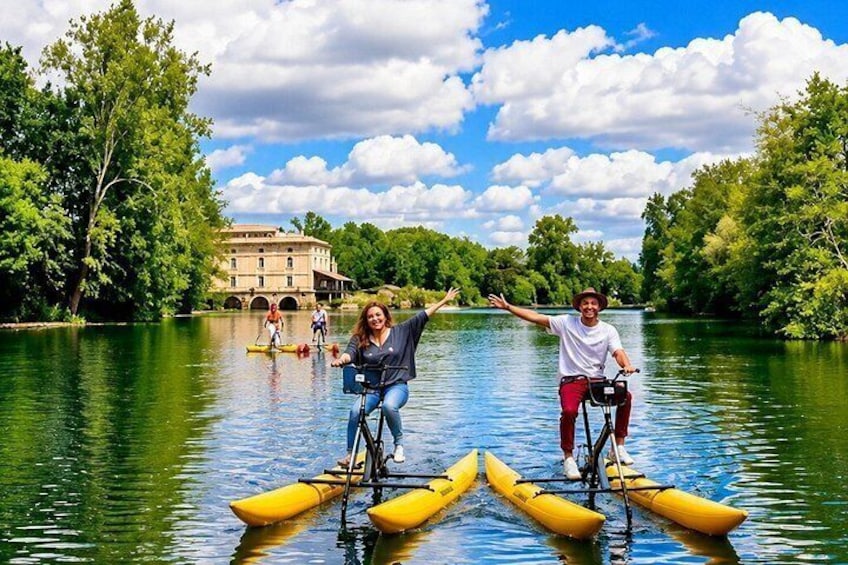 People kayaking on a river with a building in the background. 3