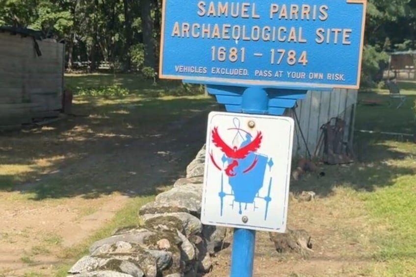 A blue sign with a red eagle and a white sign with a red bird. 2