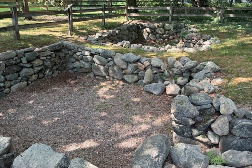 A stone wall, a wooden fence, and a grassy area. 1