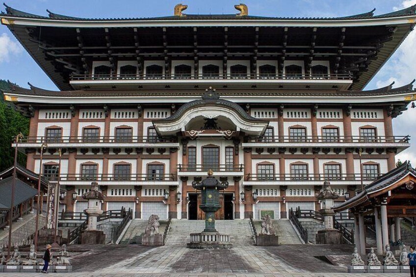 A traditional Japanese building with a large entrance, multiple windows, and a prominent roof structure. 2