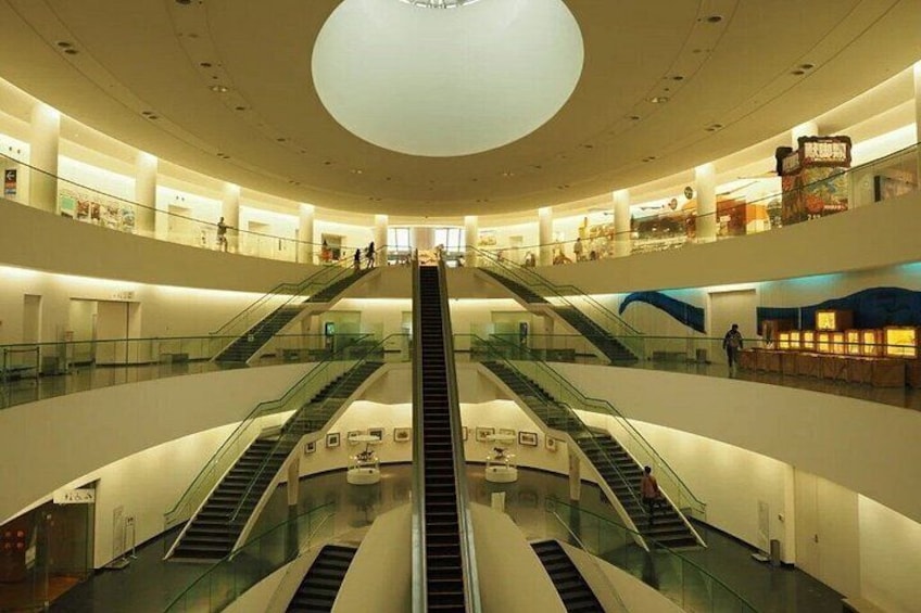 A multi-level shopping mall with escalators and glass railings. 3